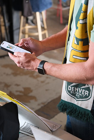 photograph of a person's arms and hands holding a phone with supporter group logo on it.