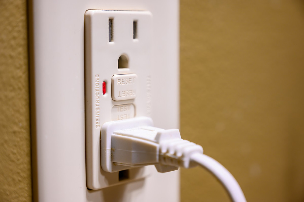A cord is plugged into a GFCI outlet