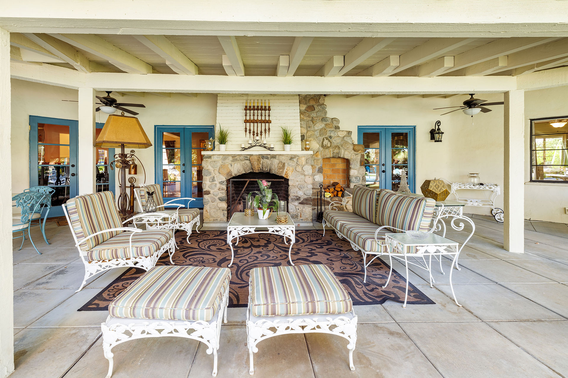 Rear loggia of 608 S Indian Trail showing vintage seating arrangement and fireplace in the background