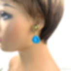 Short blue howlite clip-on earrings on a model.