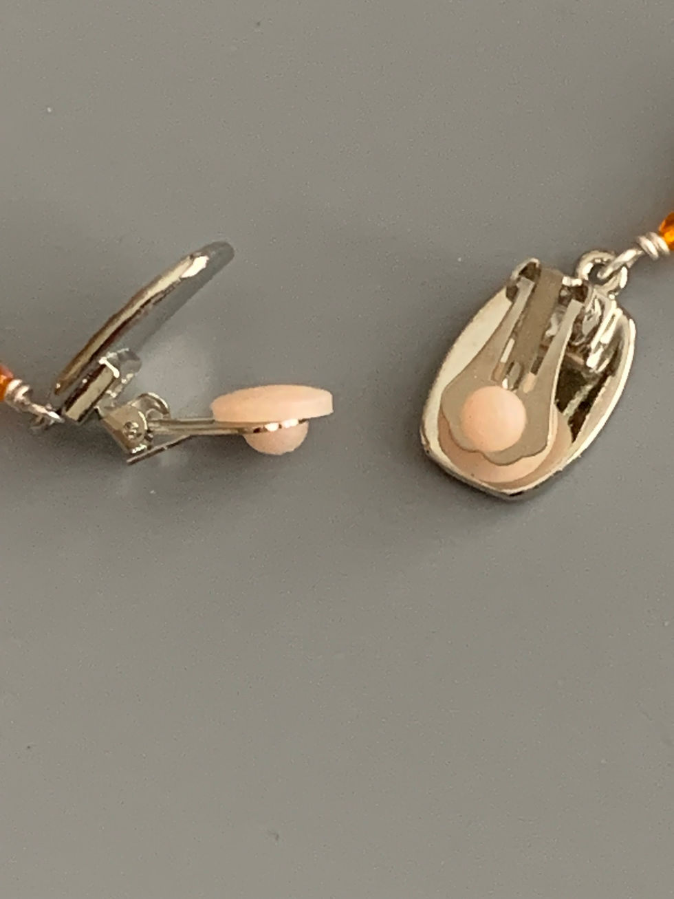 Thumbnail: Close-up of a silver jewelry clasp with beige pad
