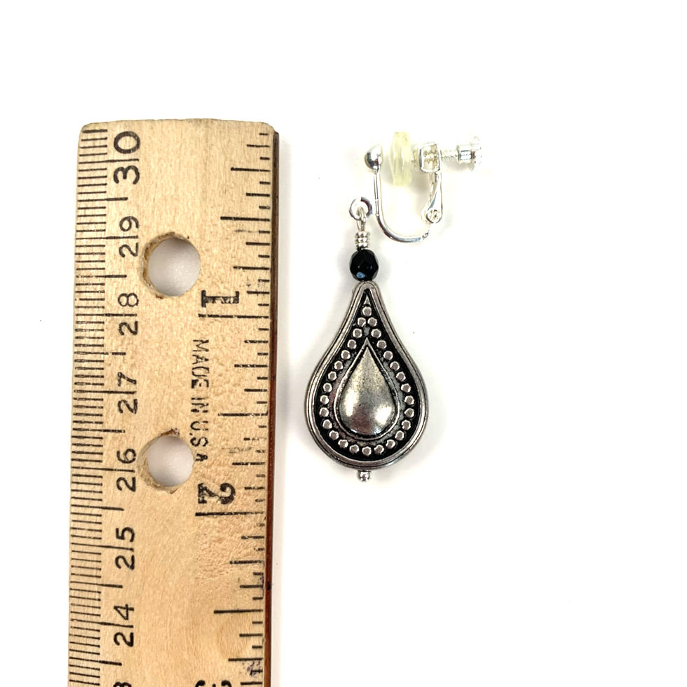 Thumbnail: Teardrop clip-on earring next to a ruler