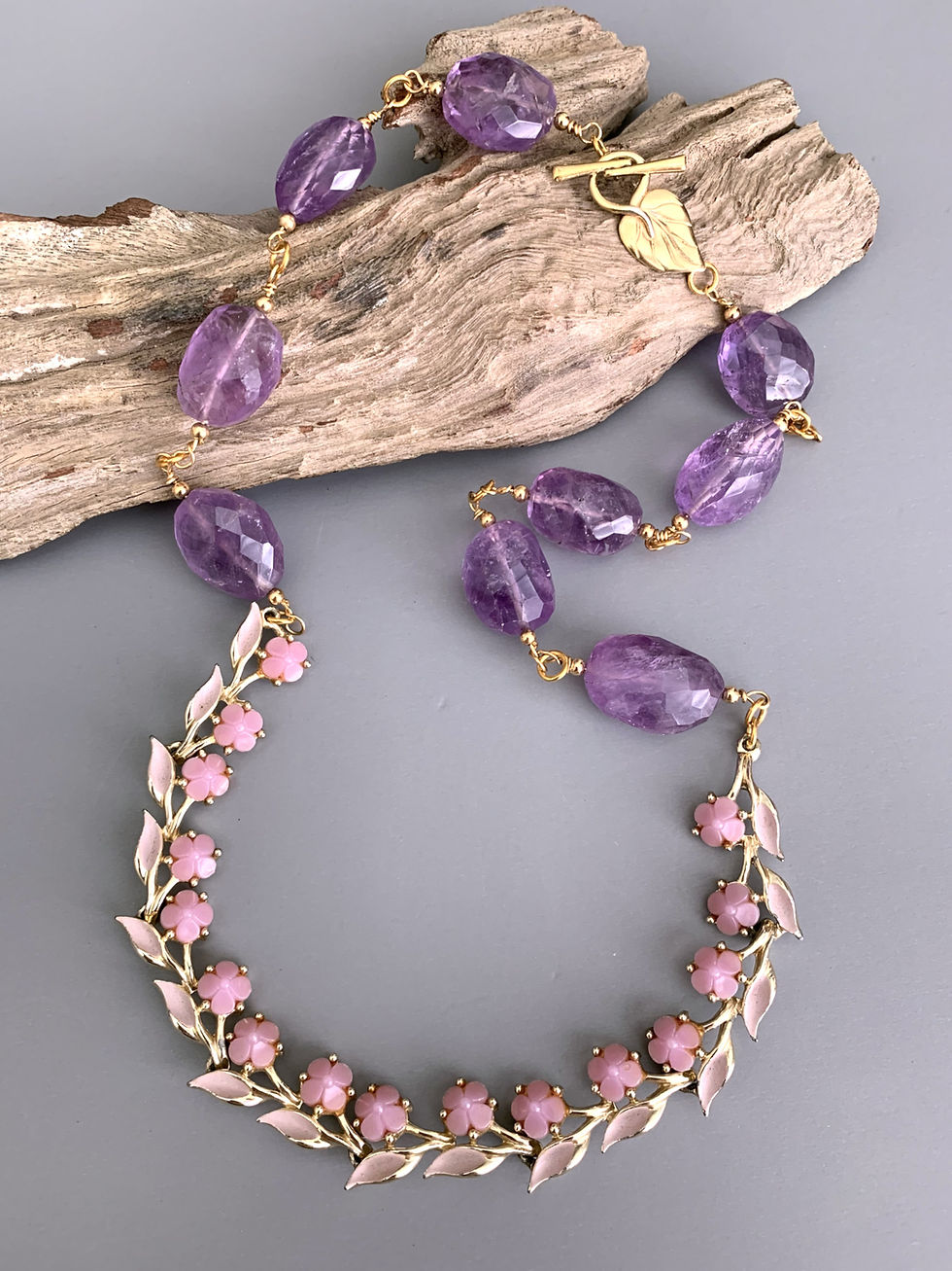 Thumbnail: Gold necklace with purple amorphous stones and pink beaded leaves