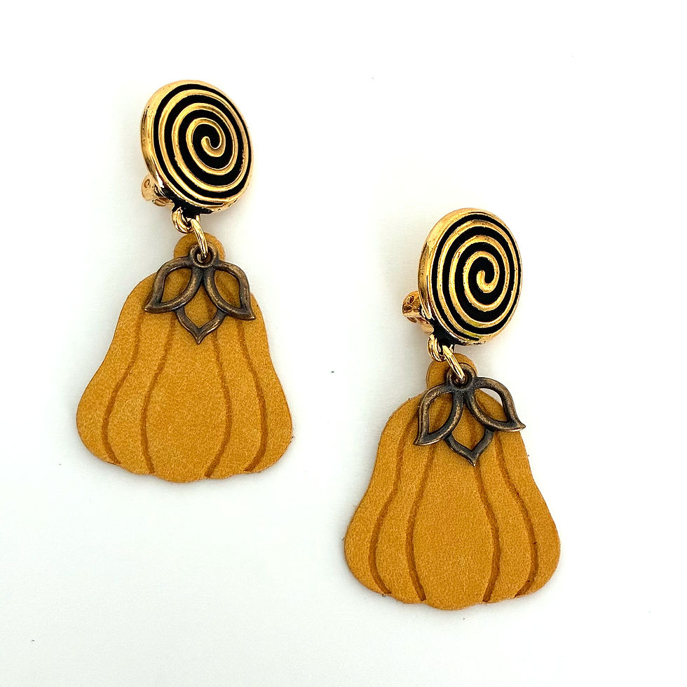Image shows two yellow pumpkin shaped clip-on earrings on a white back ground