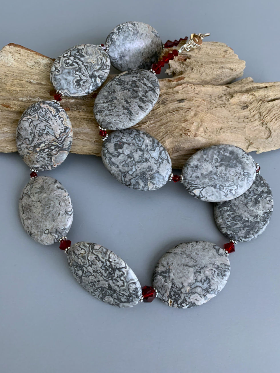Thumbnail: Grey marbled oval bead necklace on driftwood