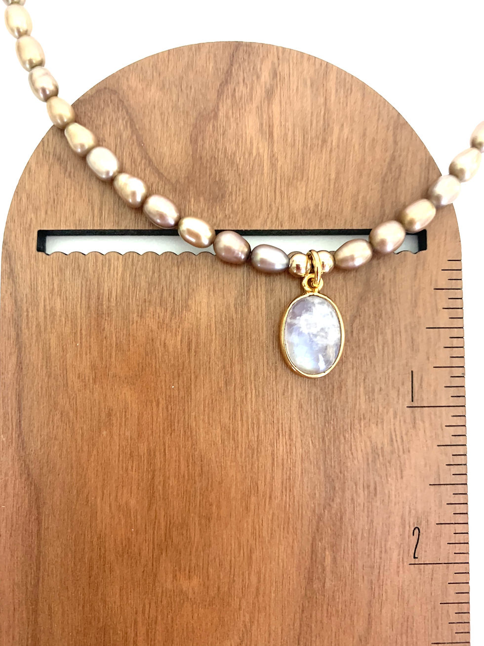 Thumbnail: Pearl necklace with iridescent oval pendant on wood stand