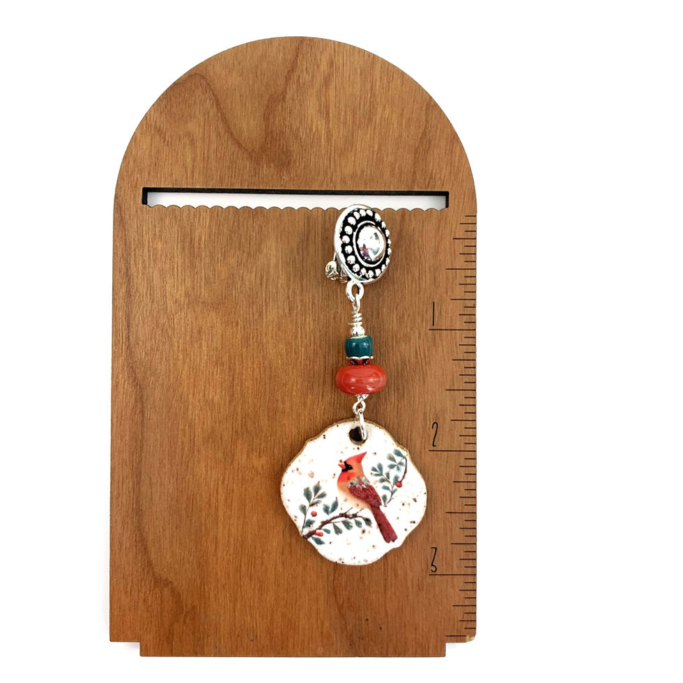 Thumbnail: Dangle earring with red cardinal charm on wooden display.