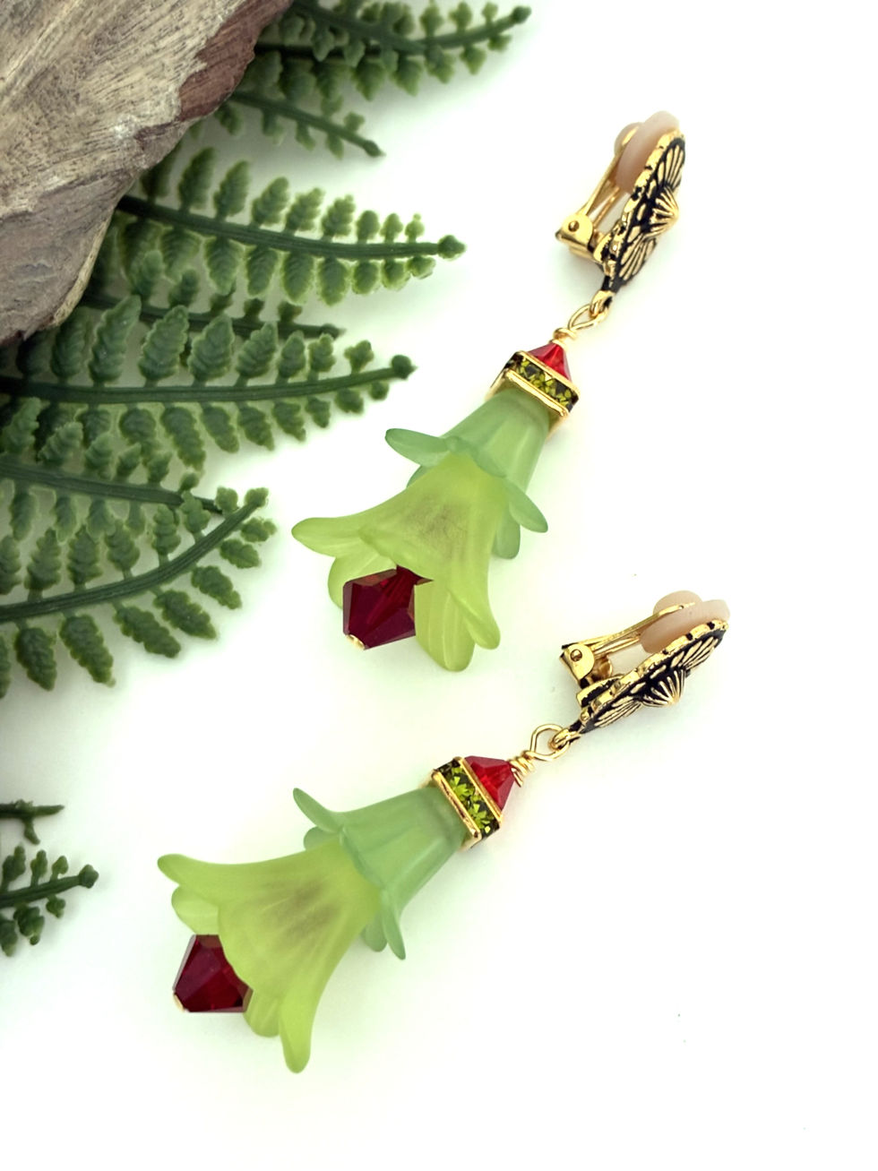 Image of green Lucite flower and red crystal earrings.