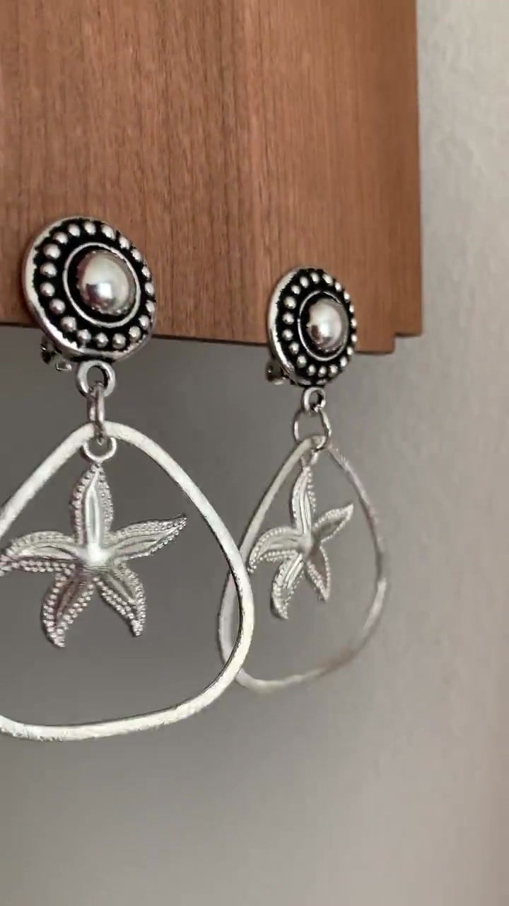 Thumbnail: Silver clip on earrings with starfish charms in the middle
