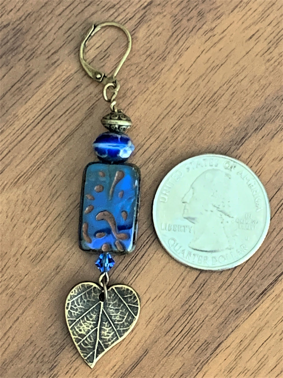 Thumbnail: Single dangle earring with blue beads and a bronze leaf charm, next to a US quarter for scale.