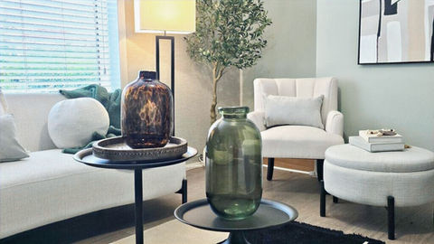Modern staged lounge featuring soft furnishings, accent tables, and decorative accessories.