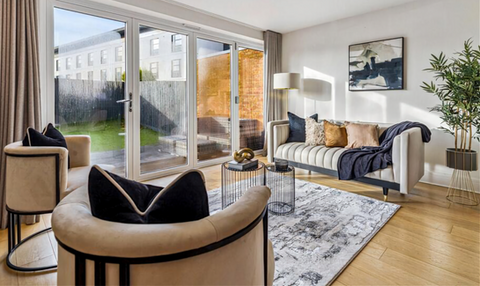 Contemporary lounge staged with neutral tones, layered accessories, and abundant natural light.
