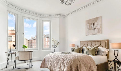 Staged master en-suite with office area, styled in creams and hints of black.