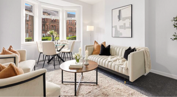 Cream leather sofa and matching armchairs, wooden coffee table with  black accents creating a bright and contemporary living space.