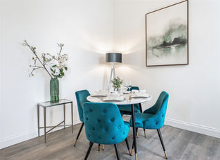 Grey and teal blue staged dining area in a Glasgow show apartment, furnished and styled by Maggie, designer and owner of Upstaged.