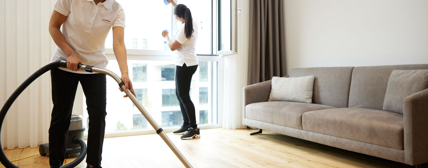 Ein professionelles Reinigungsteam der Prodoba Hotelservice AG reinigt gründlich ein luxuriöses Hotelzimmer. Sie sorgen für Sauberkeit und Hygiene, indem sie die Oberflächen abwischen, den Boden reinigen und frische Bettwäsche aufziehen.
