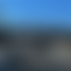 A highway overpass bridge with a couple of large signs displayed. One says Defend Democracy and the other says Regime Change Starts at Home. There are about 10 people visible behind the signs and an American flag is visible above the C in Change.