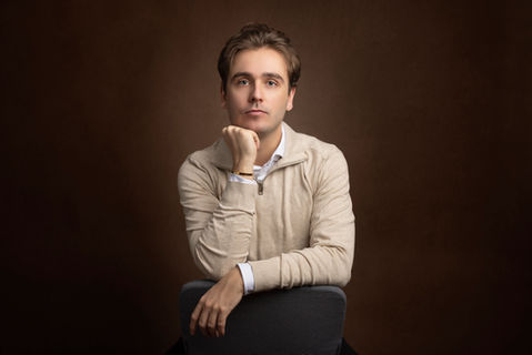 Klassisk headshot af ung mand med hånd under hagen