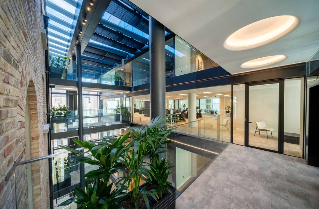 Interior atrium balcony with glazing and planted architectural details