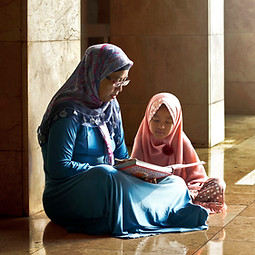 Mom Reading a Book to her Daughter