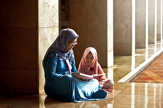 Mom Reading a Book to her Daughter