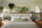 a biophilic interior design bedroom with houseplants and a soft green colour theme