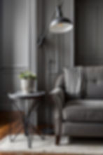 A grey chair that matches the grey Wall behind it