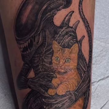 alien tattoo holding cat