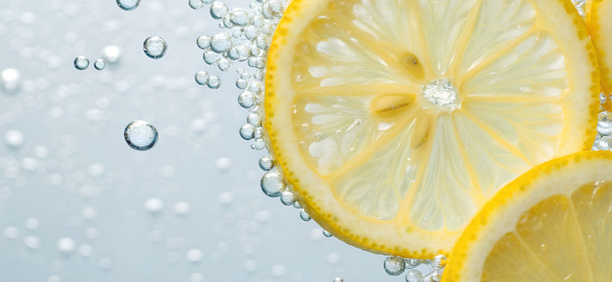 Lemon slices floating in bubbly water, with effervescent bubbles rising around them, creating a refreshing and vibrant atmosphere.
