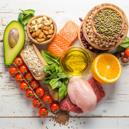 Flat lay of gut-healthy foods like salmon, avocado, lentils, and citrus on a wooden background with text “10 Delicious Recipes for Better Gut Health.”