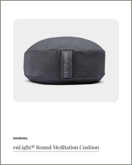 Gray round Manduka meditation cushion, supportive for seated meditation and restorative yoga.
