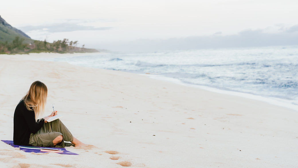 woman journaling on the beach
