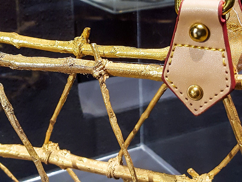 Detail of a sculptural handbag from The Objects of Desire by Beatriz Gerenstein. Handcrafted in bronze with gold patina, semi-precious stones, and exotic feathers, the contemporary artwork explores beauty, desire, craftsmanship, and cultural identity.