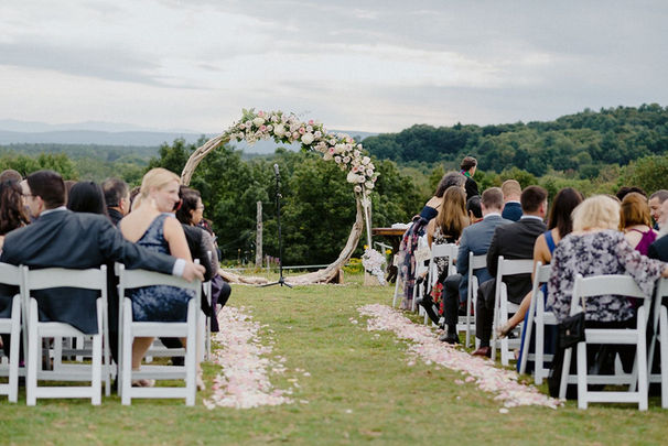 Wedding guests seated outdoors at Stable Gate Winery ceremony with mountain views in the background.