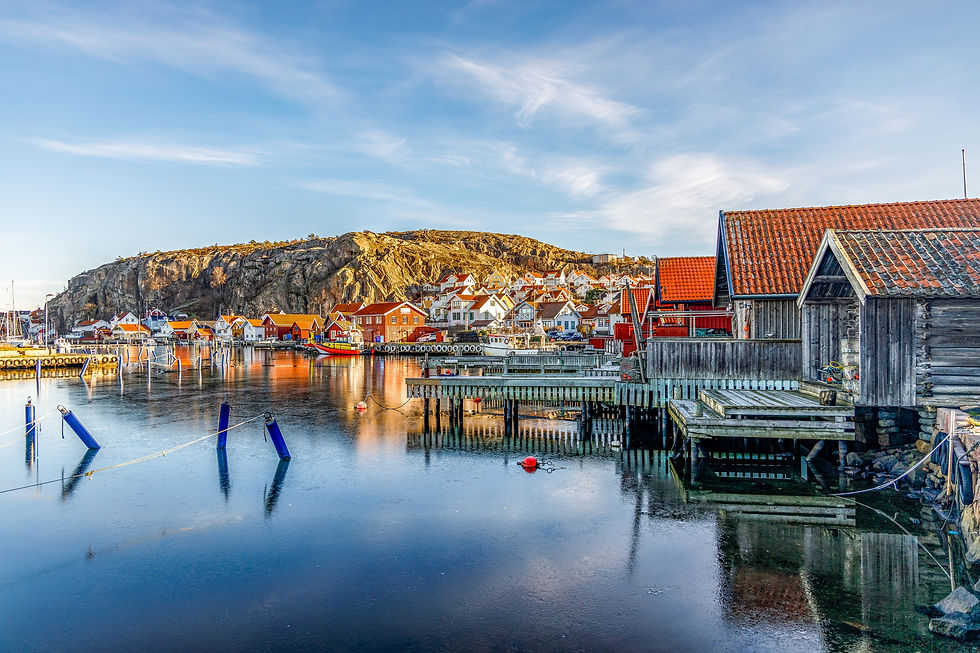Scenic coastal town with red houses, blue water and a beautiful sky.