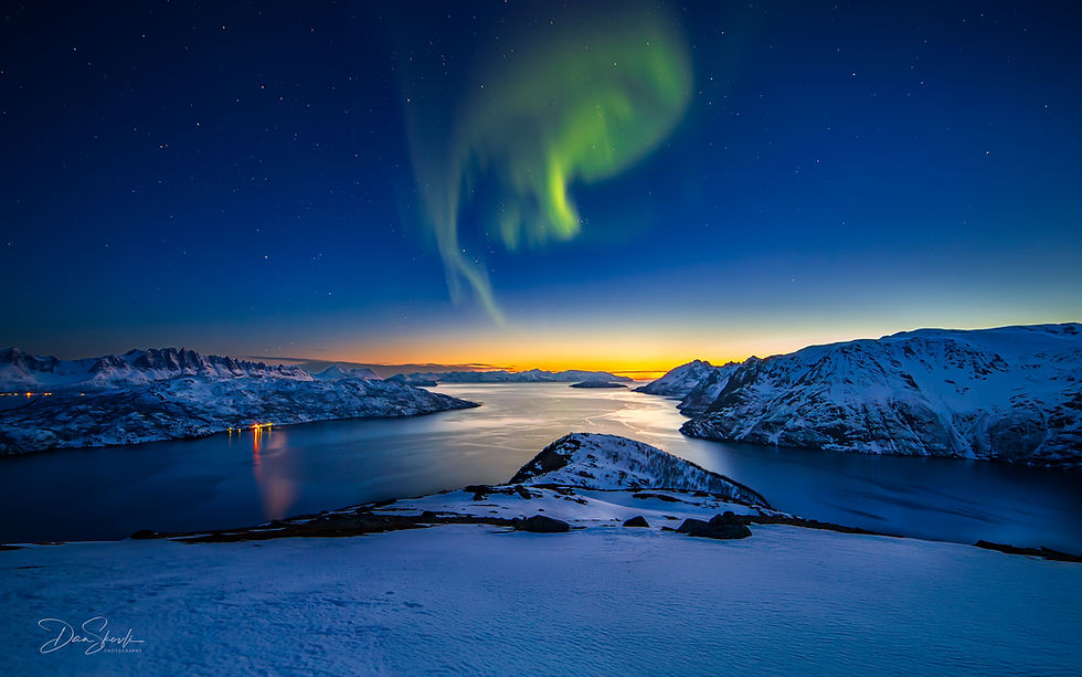 Nordlys over snødekt landskap og vann, I varme , lune omgivelser trives en , selv om snøstormen raser.