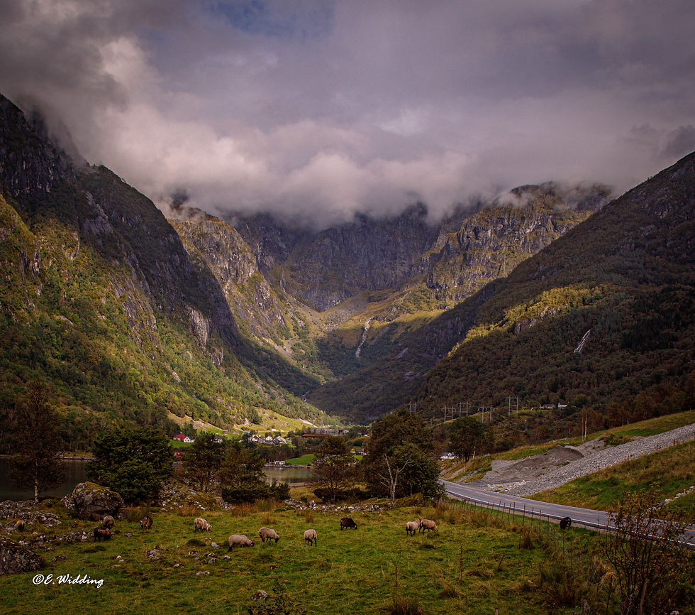 Grønn dal med fjell og skyer; Høy sjø ved Gula Humpen i Grebbestad. Nydelig natur.