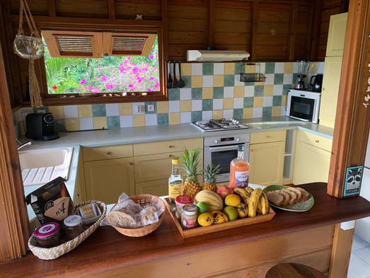 Comptoir de cuisine en bois, fruits frais, pâtisseries, vacances sérénité guadeloupe.