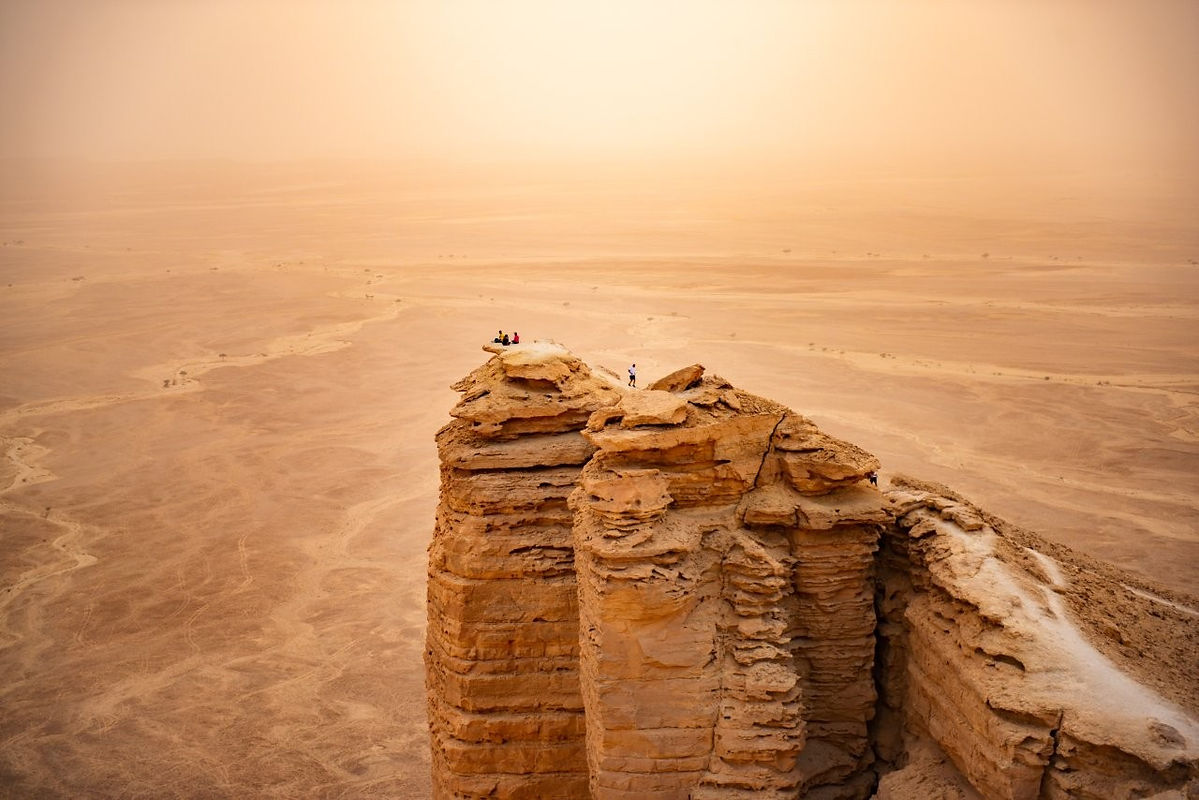 An aerial, distant view of daring adventure seekers in Western dress taking in the spectac