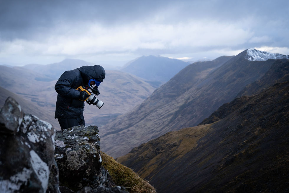 alt=“Jimmy Hyland of JHP Visuals filming footage with camera in the mountains of the Scottish Highlands"