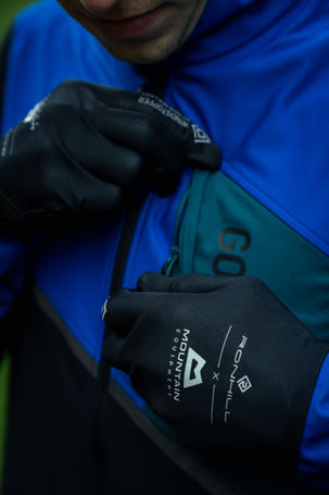 alt=“trail runner zipping Ronhill jacket during a still and video campaign for their Tech Gore-Tex Windstopper Jacket, filmed by JHP Visuals"