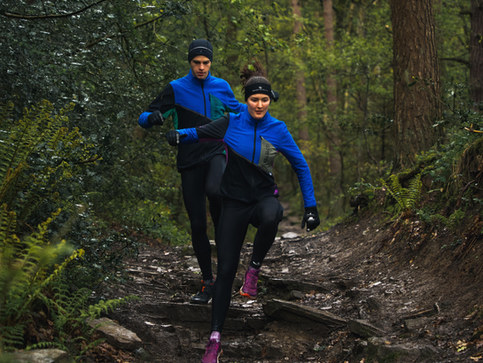 alt="two trail runners captured in a forest in the Peak District during a still and video campaign for their Tech Gore-Tex Windstopper Jacket, filmed by JHP Visuals"