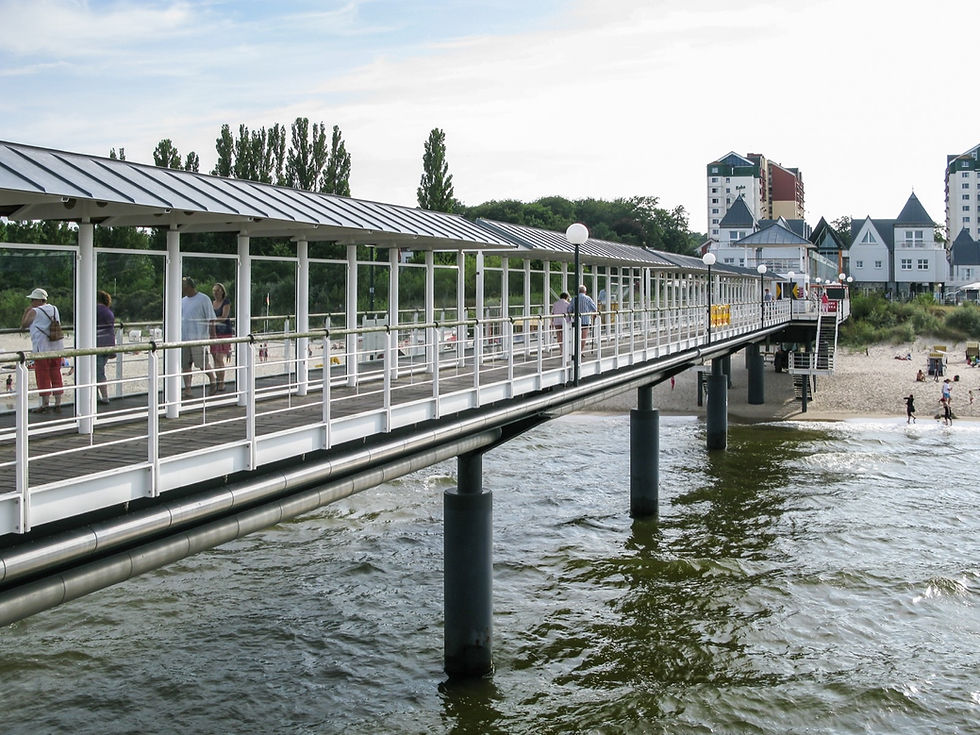 Looking along the covered walkway of the Heringsdorf pier towards the beach and resort buildings