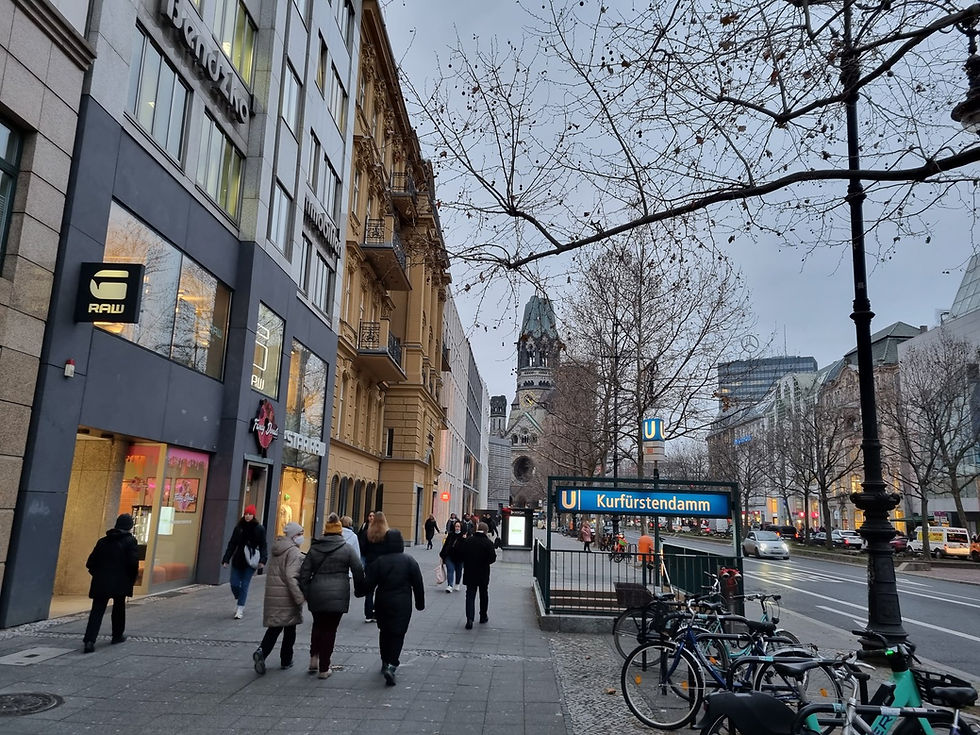 Shops and a U-Bahn entrance on the Kurfürstendamm with the Memorial Church tower behind