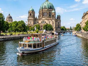 A classic sightseeing boat MS Berlin cruising on the Spree River in front of the Berlin Cathedral.