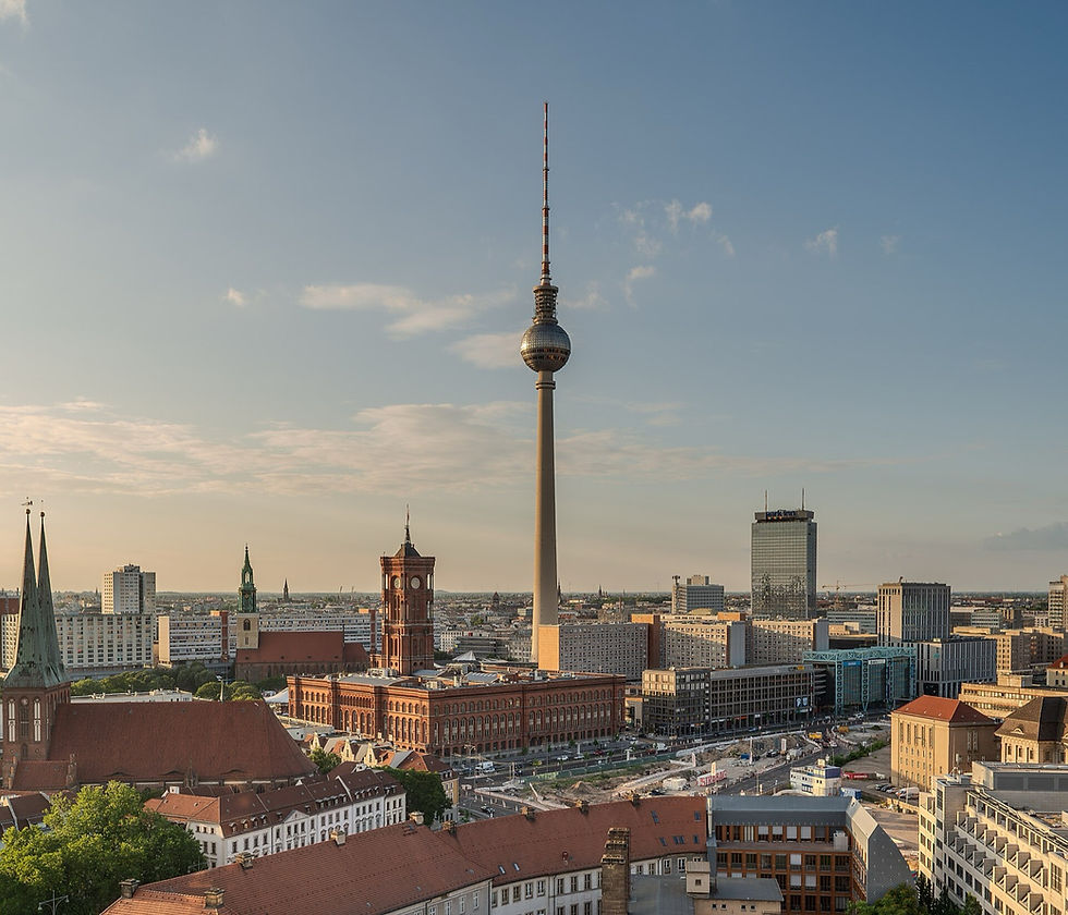 The Berlin TV Tower rising above the Mitte rooftops in low golden light