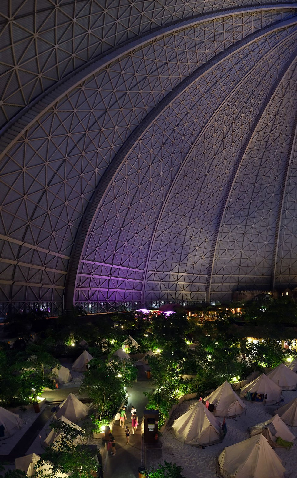 Tents of the overnight camp under the Tropical Islands dome at night