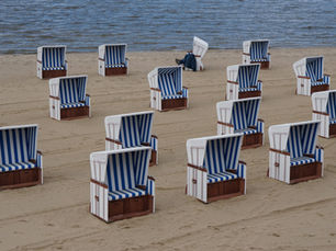Rows of blue and white striped wicker beach chairs on the sand at Strandbad Wannsee