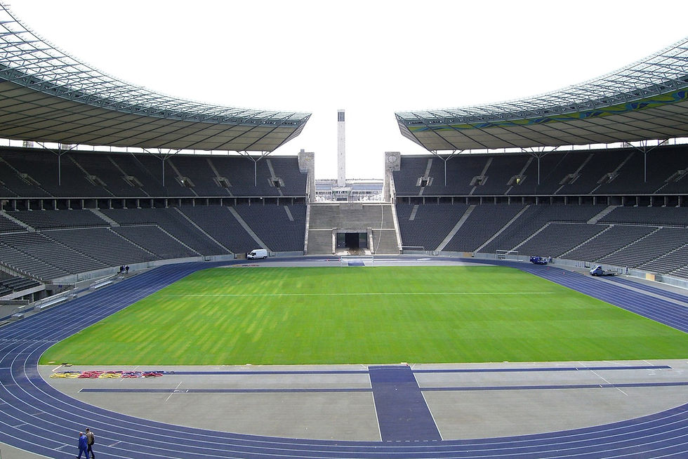 The interior of Berlin's Olympiastadion showing the blue running track separating the seating from the pitch