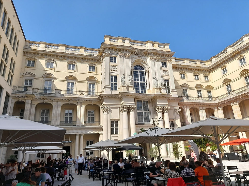 The Schlüterhof courtyard at the Humboldt Forum in Berlin, with café tables and visitors in front of the baroque façade